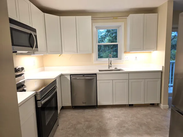 a kitchen with a sink stove and microwave