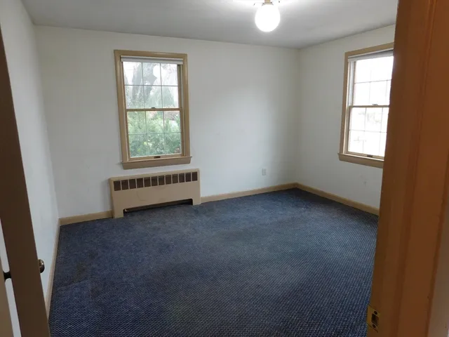 an empty room with a ceiling fan and window
