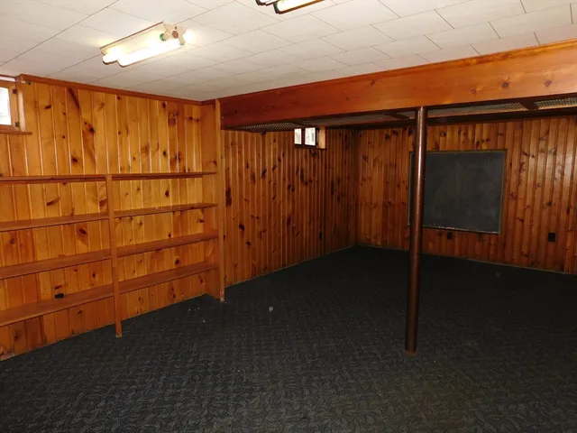 an empty room with a fireplace and cabinet