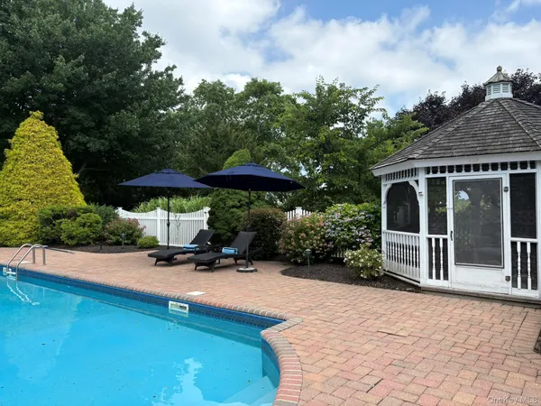 swimming pool view with a seating space