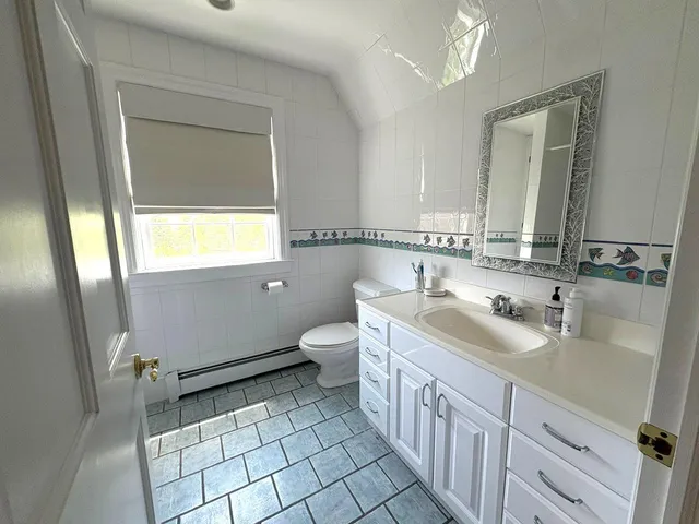a bathroom with a sink a toilet and mirror