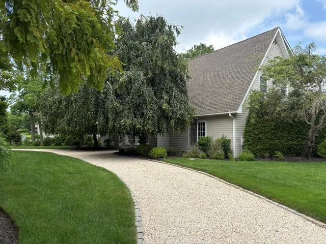 an aerial view of a house with a yard and large trees