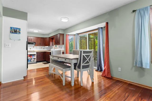a view of a dining room with furniture a chandelier and wooden floor