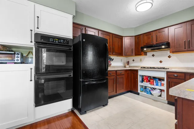 a kitchen with stainless steel appliances granite countertop a refrigerator stove and sink