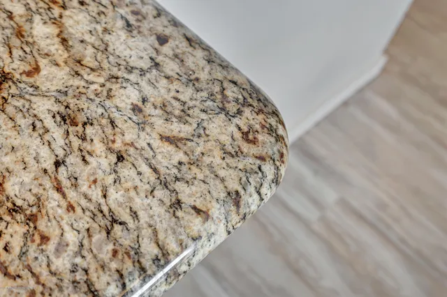 a kitchen with granite countertop white cabinets and stainless steel appliances