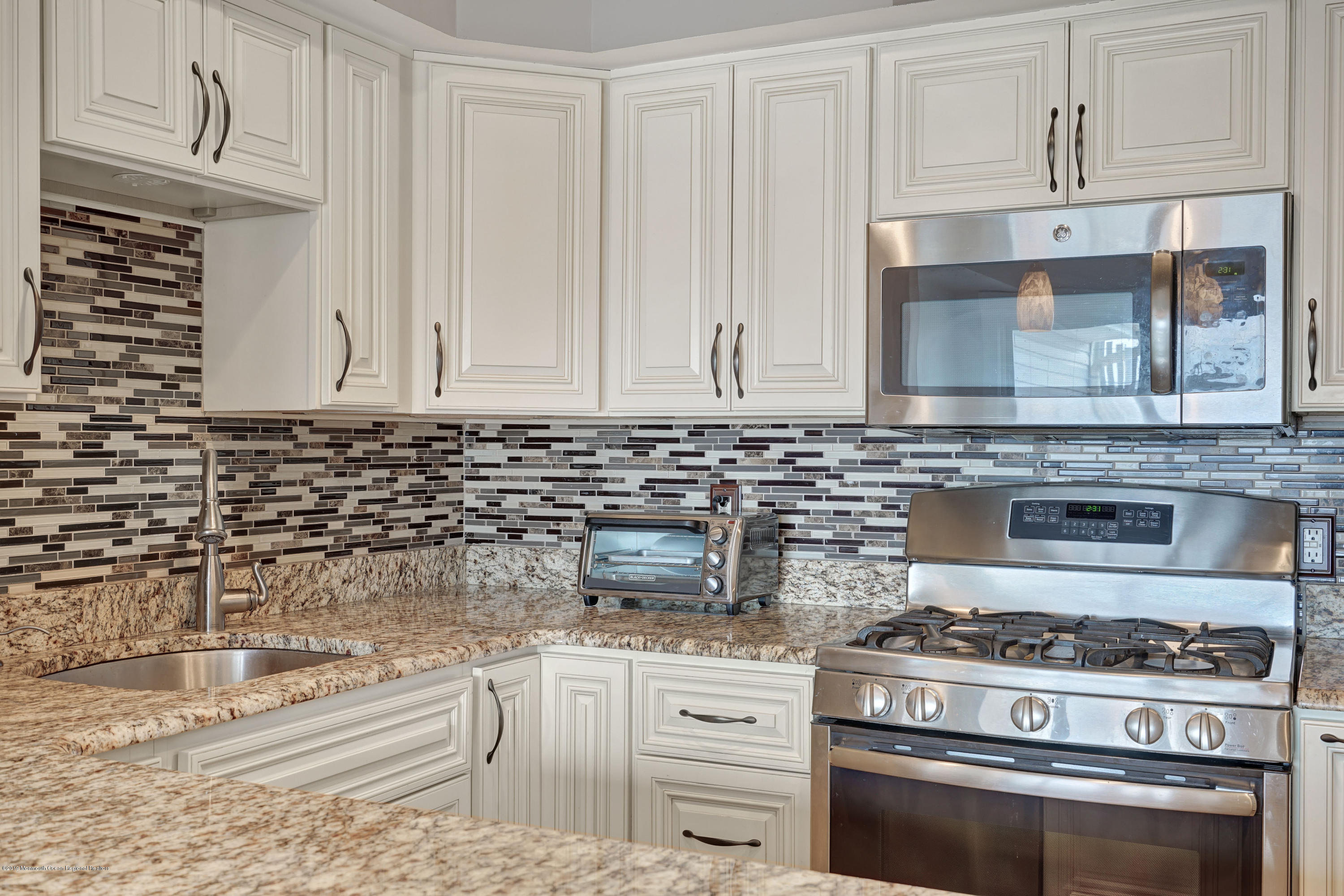 42 Hamilton Avenue, Unit B11 Seaside Heights, NJ 08751 - Photo 18 of 24 a kitchen with granite countertop white cabinets and stainless steel appliances