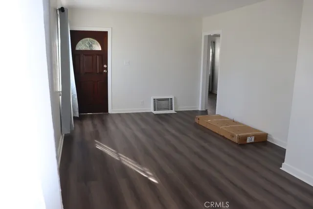 a view of an empty room with wooden floor
