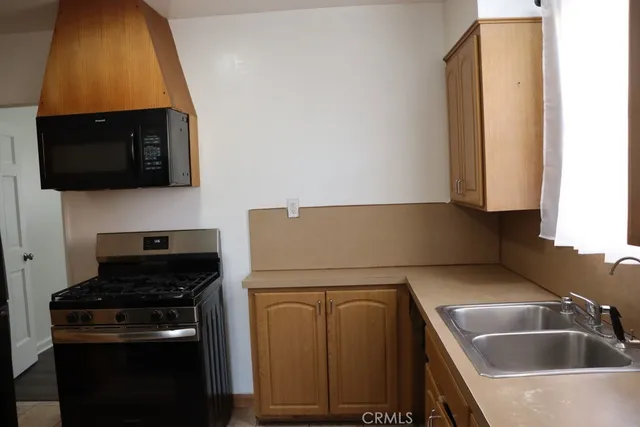 a kitchen with wooden cabinets and a stove top oven