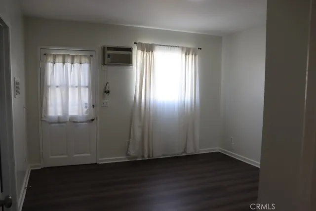 an empty room with wooden floor and closet area