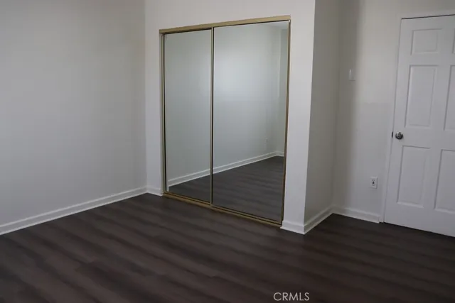 an empty room with wooden floor and window