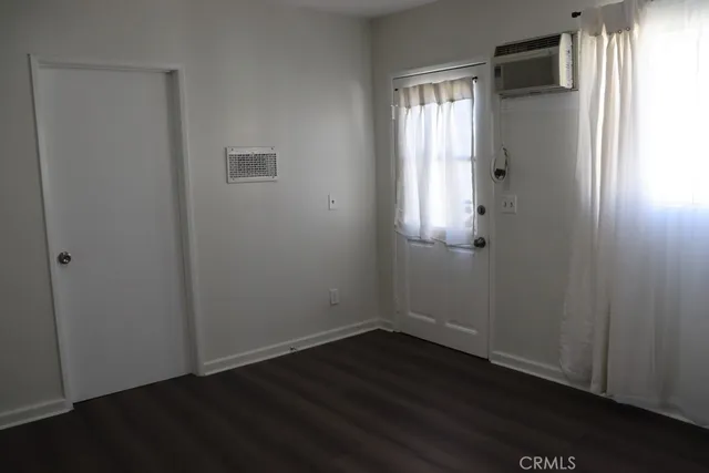 an empty room with wooden floor and closet