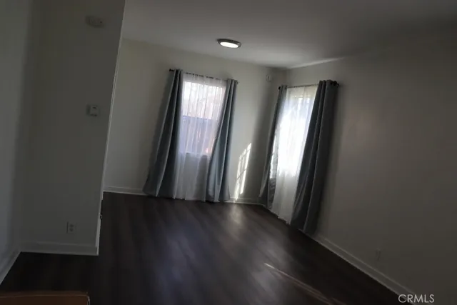 an empty room with wooden floor and closet