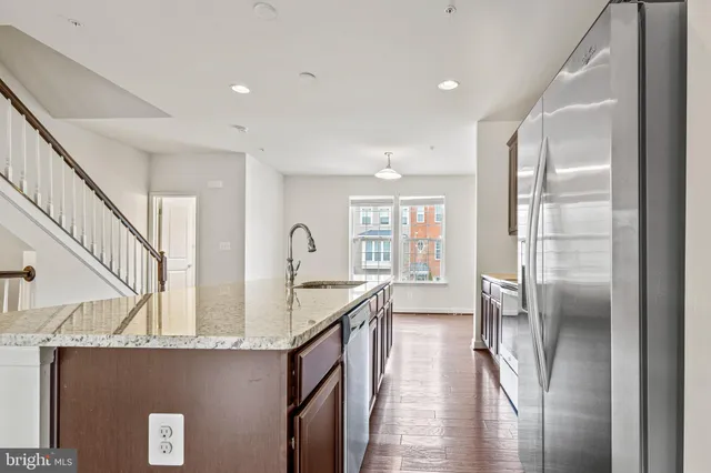 a kitchen with stainless steel appliances granite countertop a refrigerator and a sink