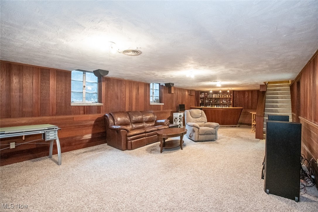 13740 Old Pleasant Valley Road Cleveland, OH 44130 - Photo 23 of 28 Living area with a dry bar, wood walls, and carpet floors