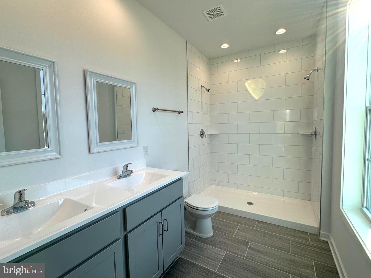 13 Glenaire Road Bunker Hill, WV 25413 - Photo 16 of 23 a bathroom with a double vanity sink a toilet and shower