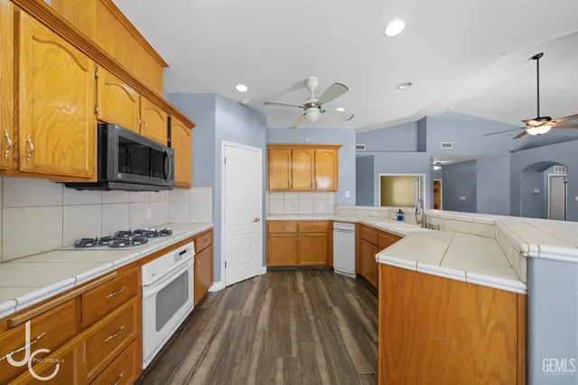 a kitchen with a sink a counter top space stainless steel appliances and cabinets