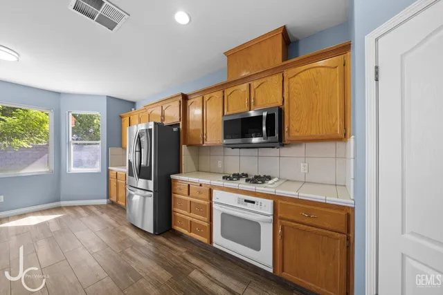 a kitchen with stainless steel appliances granite countertop a refrigerator microwave and sink