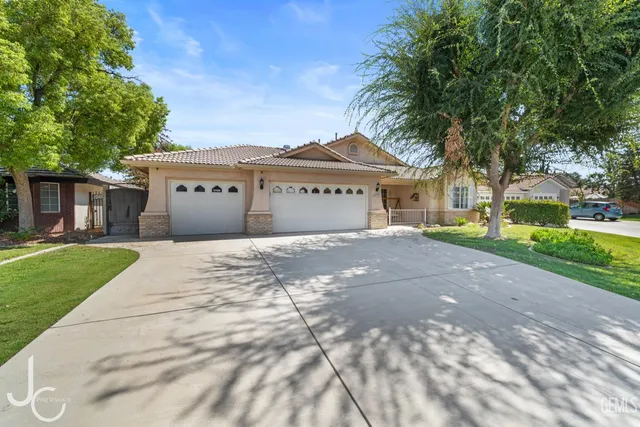 a front view of a house with a garden and trees