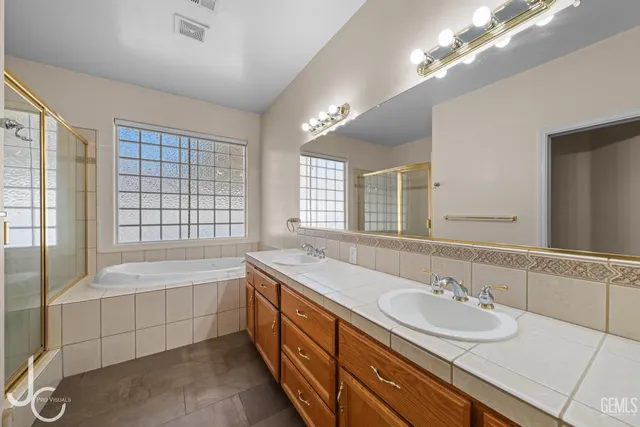 a bathroom with double vanity sinks and a bathtub