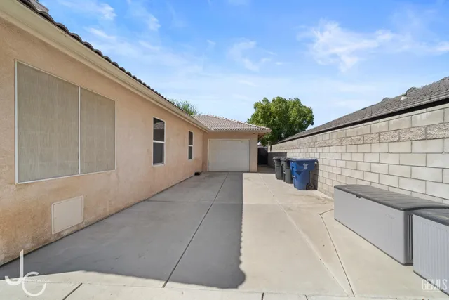 a view of house with backyard and trees in the background