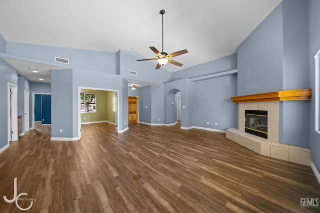 a view of a livingroom with a fireplace a chandelier and wooden floor