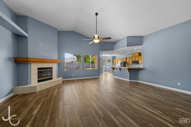 a view of a livingroom with wooden floor and a fireplace