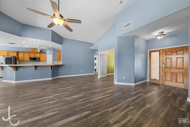 a view of an empty room with window and wooden floor