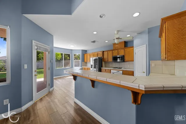 a large kitchen with stainless steel appliances lots of counter space and a sink