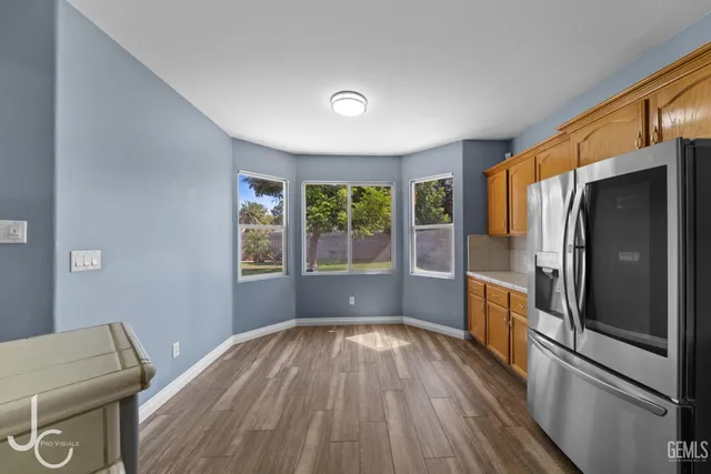 a kitchen with a refrigerator and wooden floor