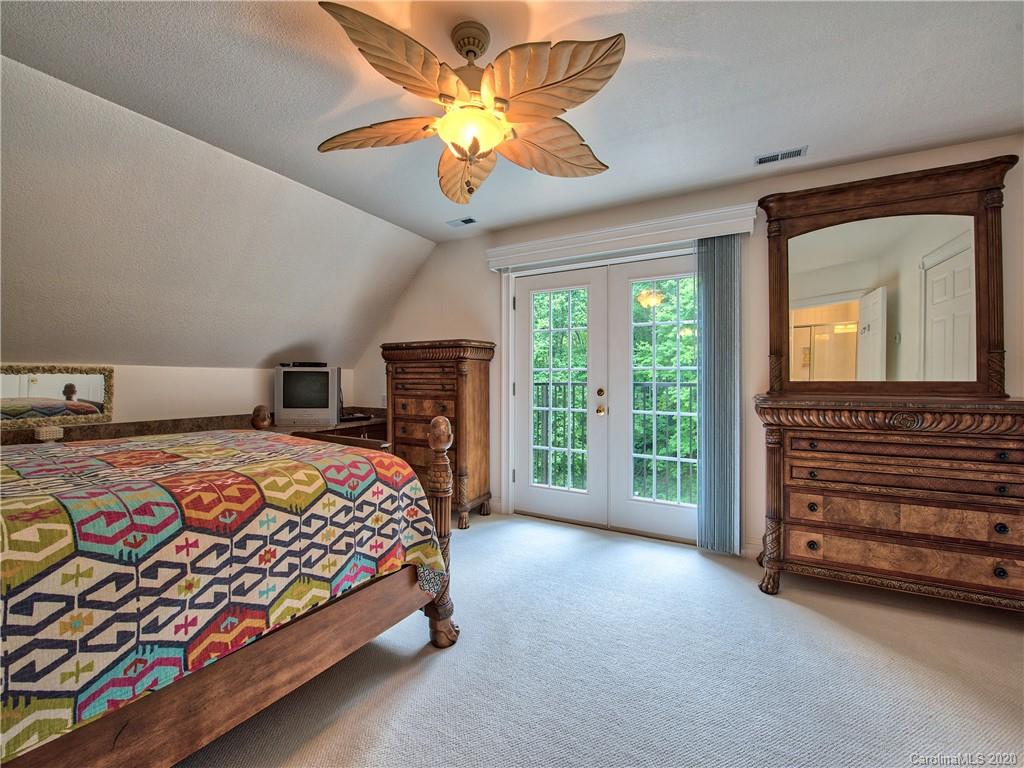 624 Bent Tree Road Maggie Valley, NC 28751 - Photo 22 of 48 a bedroom with a bed and a chandelier