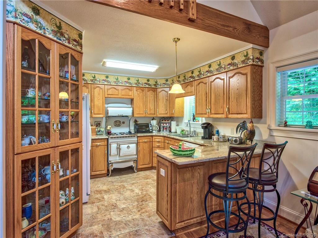 624 Bent Tree Road Maggie Valley, NC 28751 - Photo 7 of 48 a kitchen with a table chairs stove and cabinets