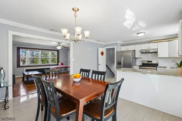 a view of a dining room with furniture and a chandelier