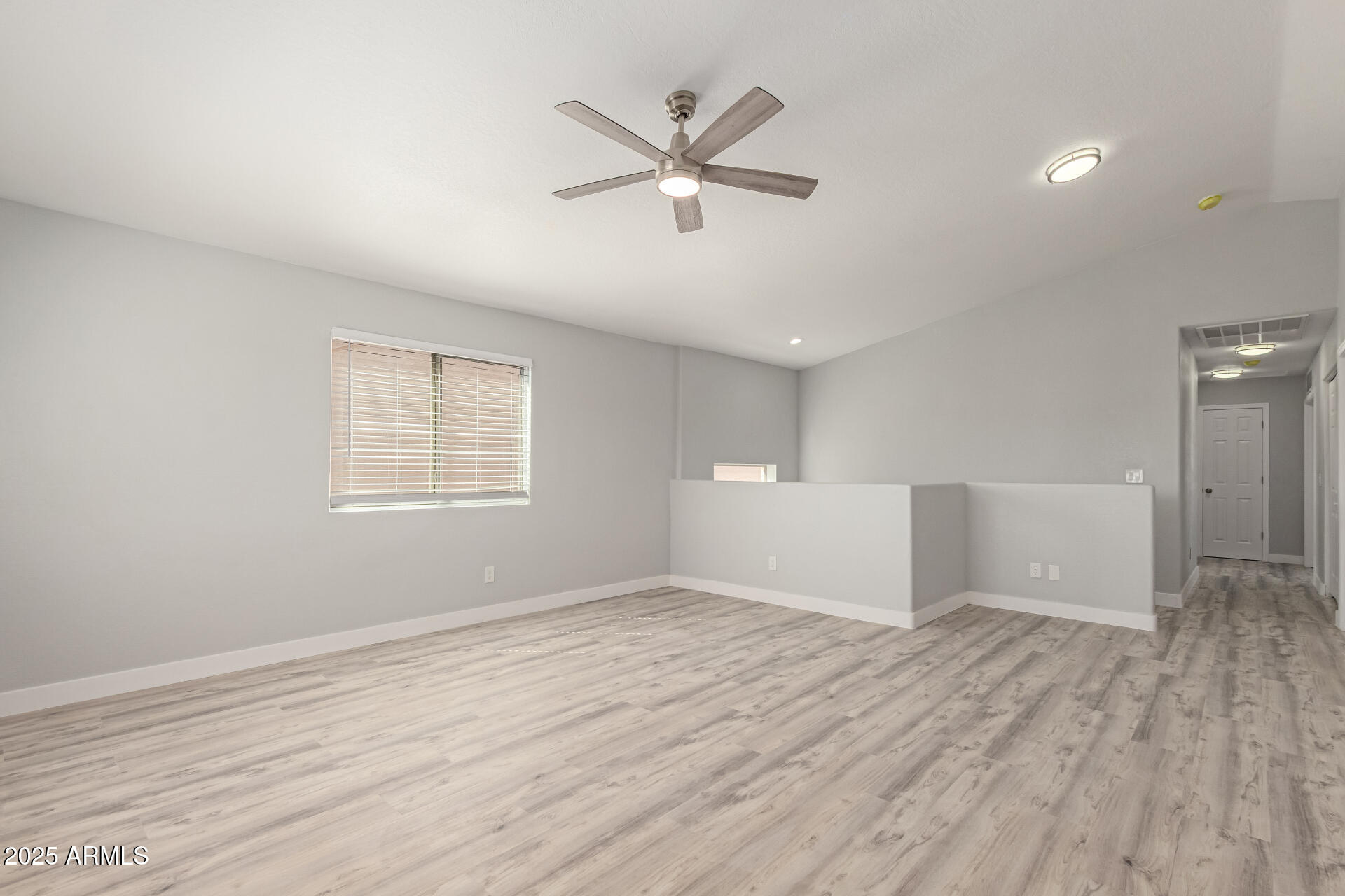 8315 West Crown King Road Tolleson, AZ 85353 - Photo 11 of 31 an empty room with wooden floor and windows