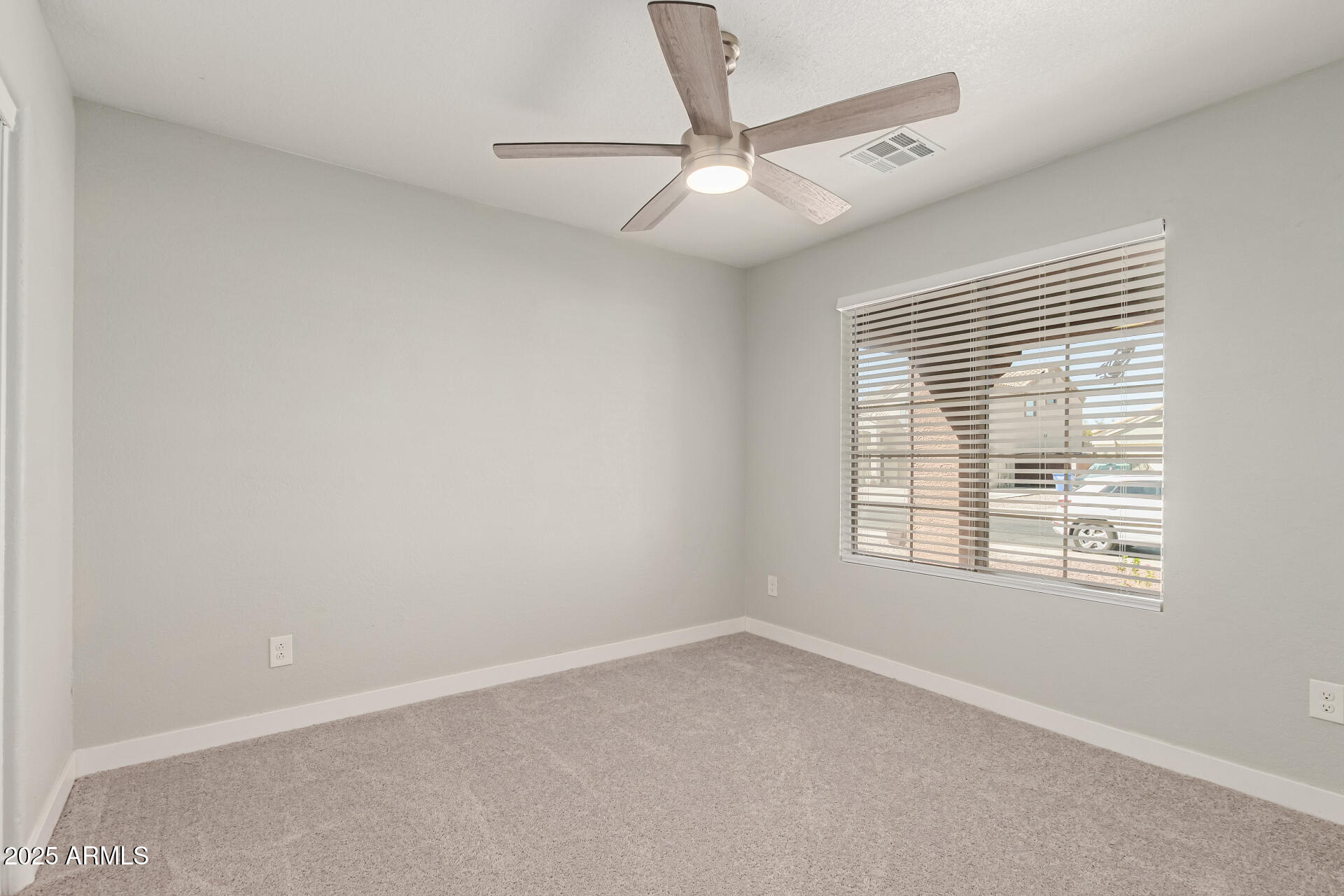 8315 West Crown King Road Tolleson, AZ 85353 - Photo 21 of 31 an empty room with a window and a fan