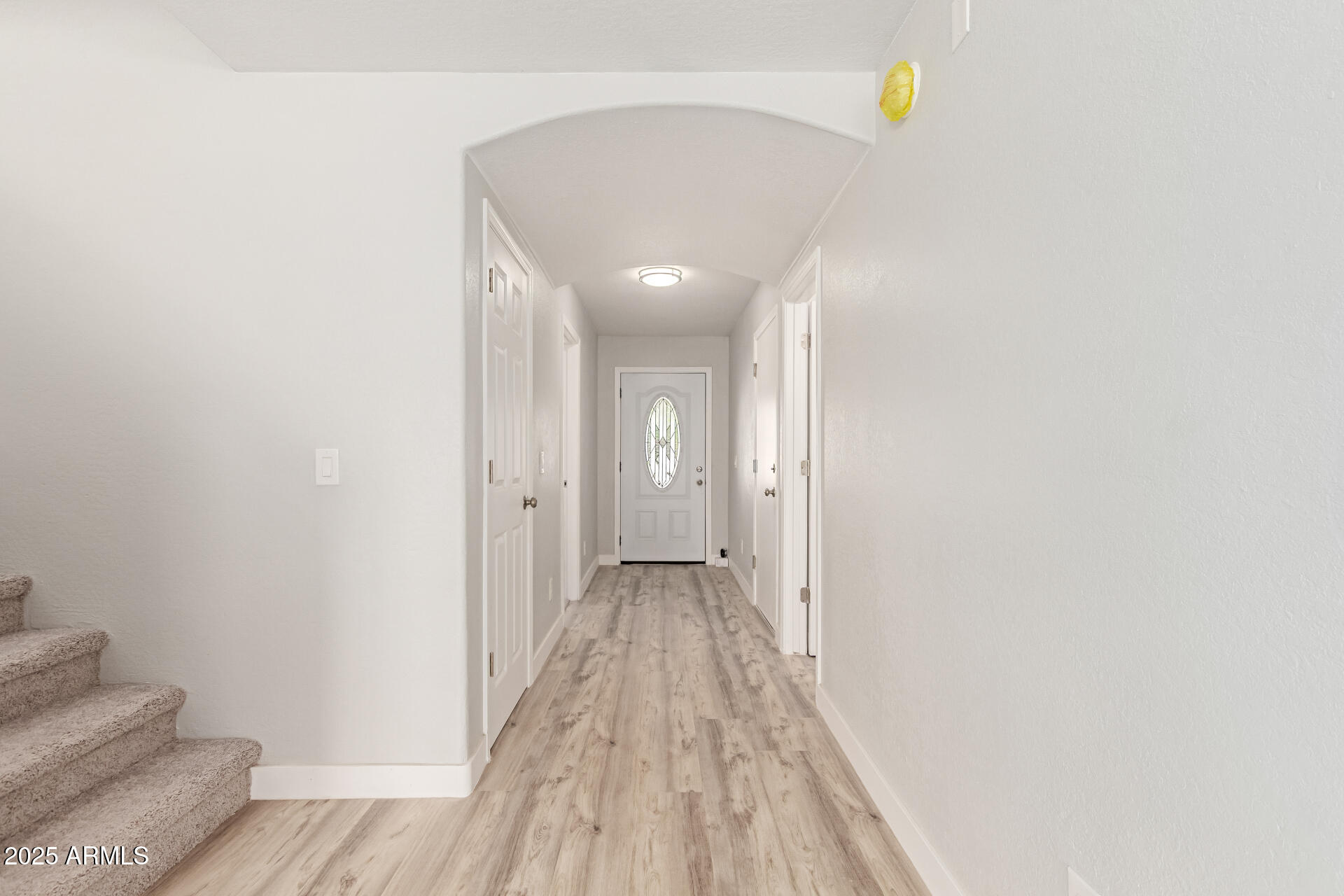 8315 West Crown King Road Tolleson, AZ 85353 - Photo 3 of 31 a view of a hallway with wooden floor and a bathroom