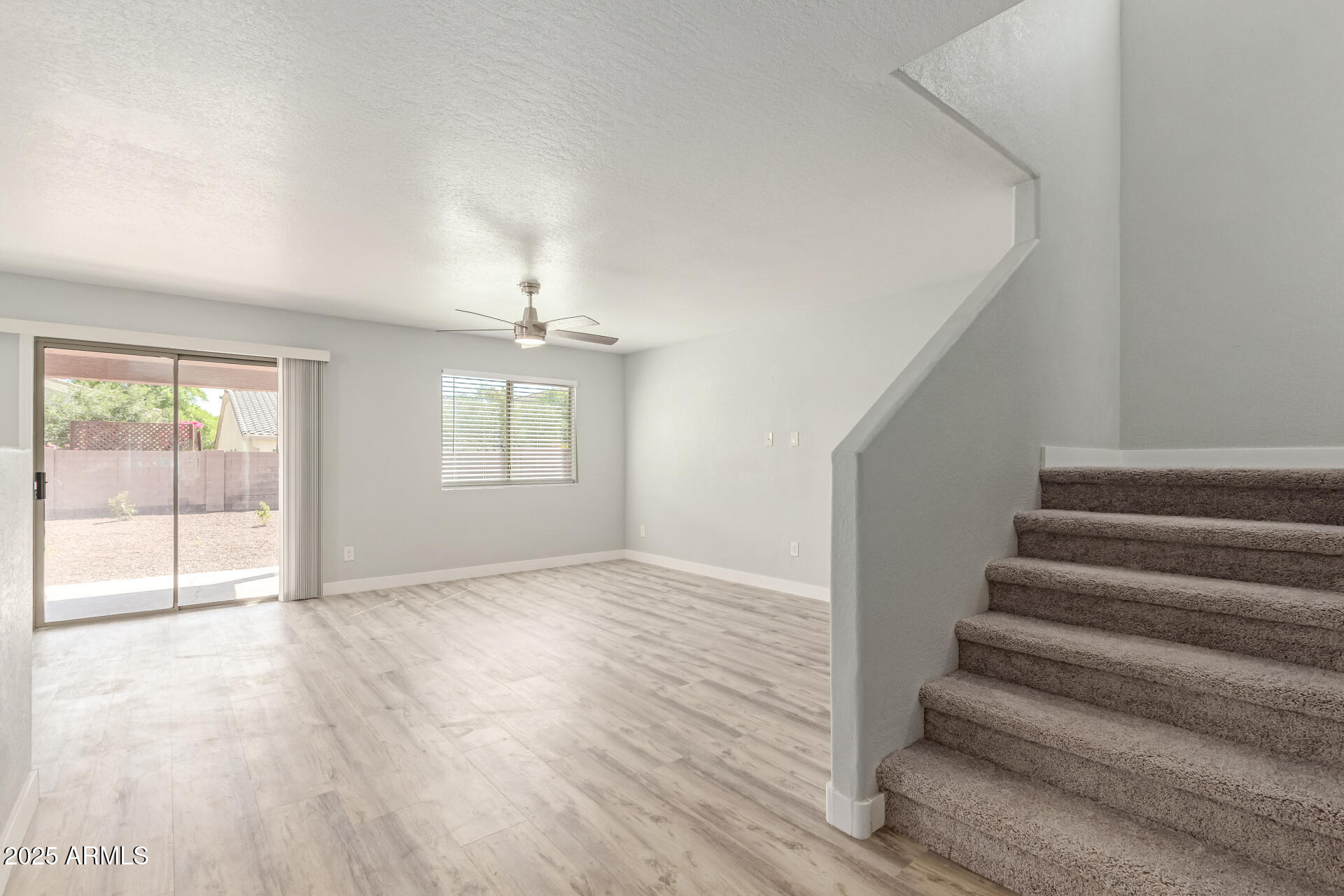 8315 West Crown King Road Tolleson, AZ 85353 - Photo 4 of 31 a view of an empty room with wooden floor and a window