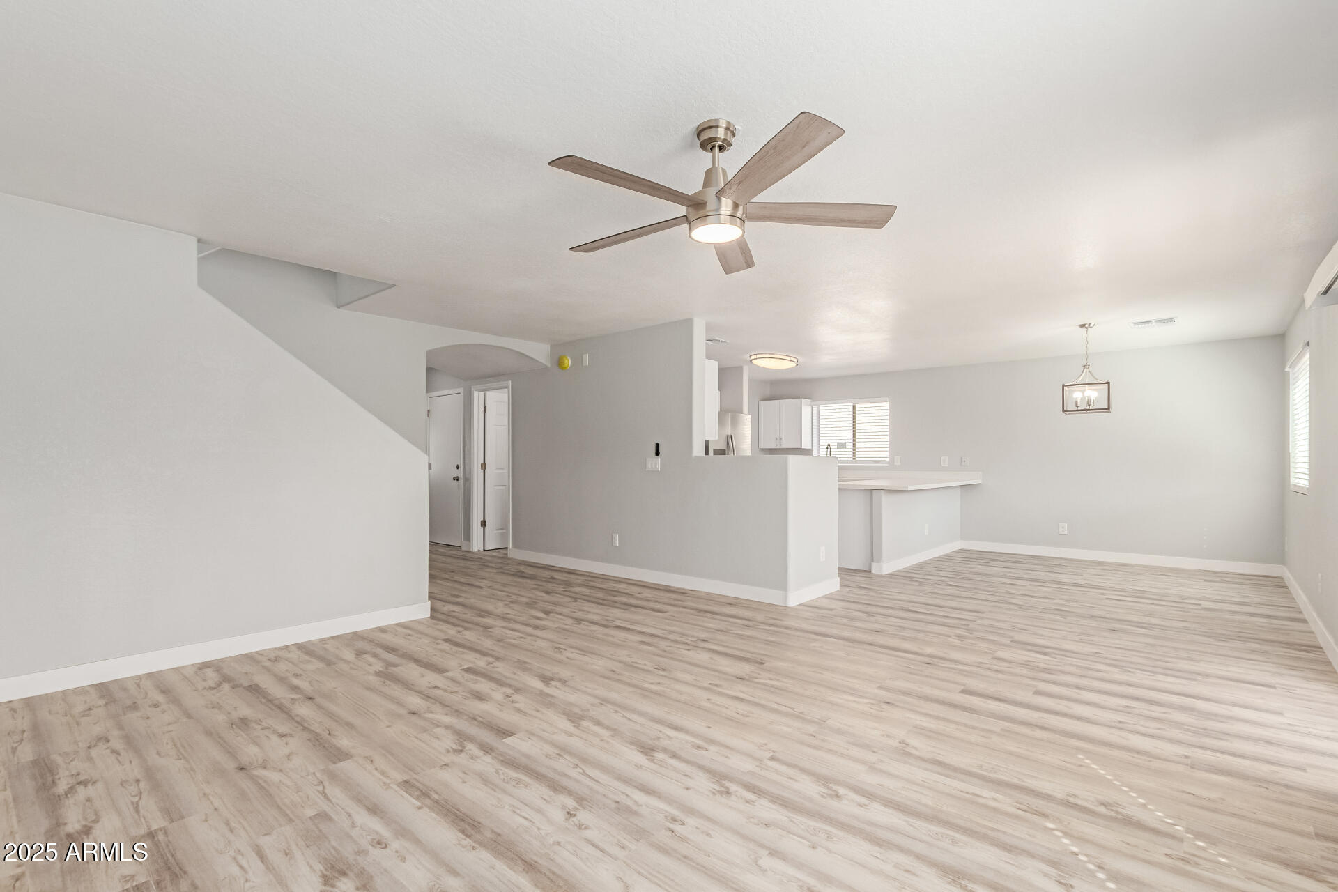 8315 West Crown King Road Tolleson, AZ 85353 - Photo 5 of 31 a view of empty room with wooden floor and ceiling fan