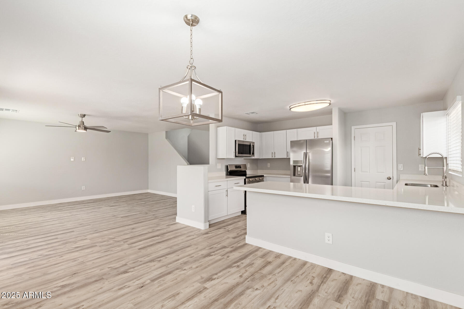 8315 West Crown King Road Tolleson, AZ 85353 - Photo 6 of 31 a view of a kitchen with center island and stainless steel appliances