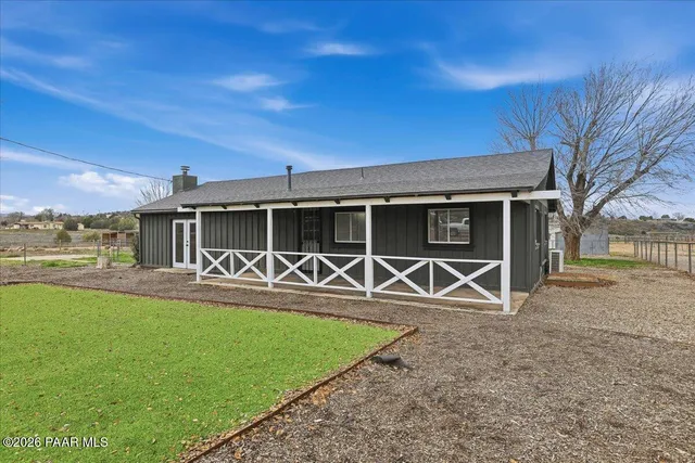 a view of a house with backyard and a tree