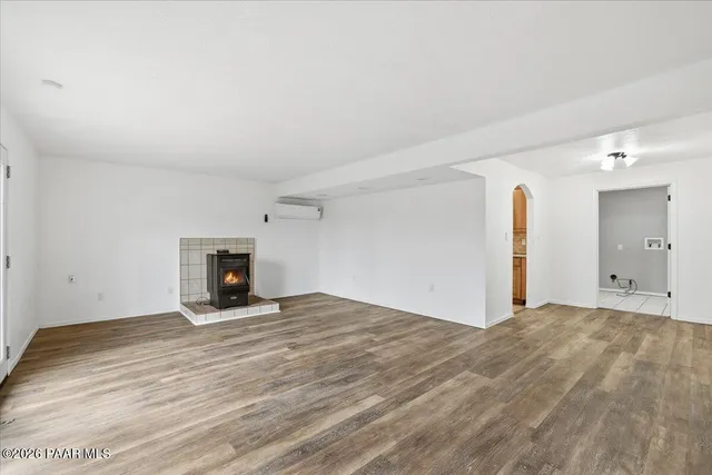 a view of empty room with wooden floor and fireplace