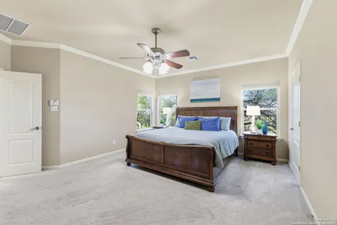 a bedroom with a large bed and a chandelier