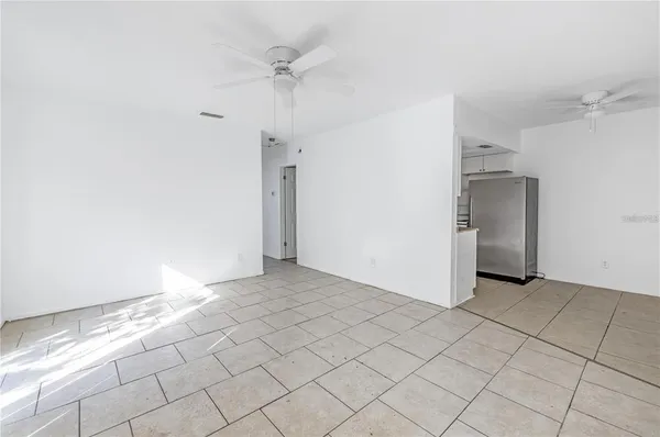 an empty room with a ceiling fan and carpet