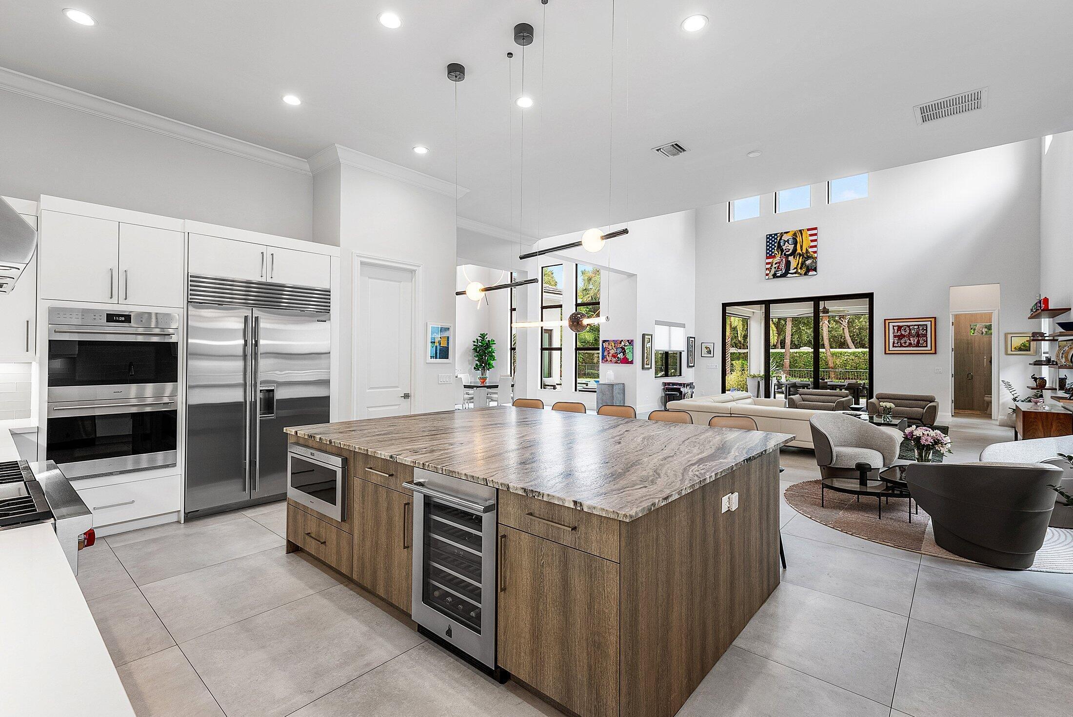 2707 Northwest 75th Street Boca Raton, FL 33496 - Photo 16 of 74 a kitchen with kitchen island a counter top space a sink stainless steel appliances and cabinets