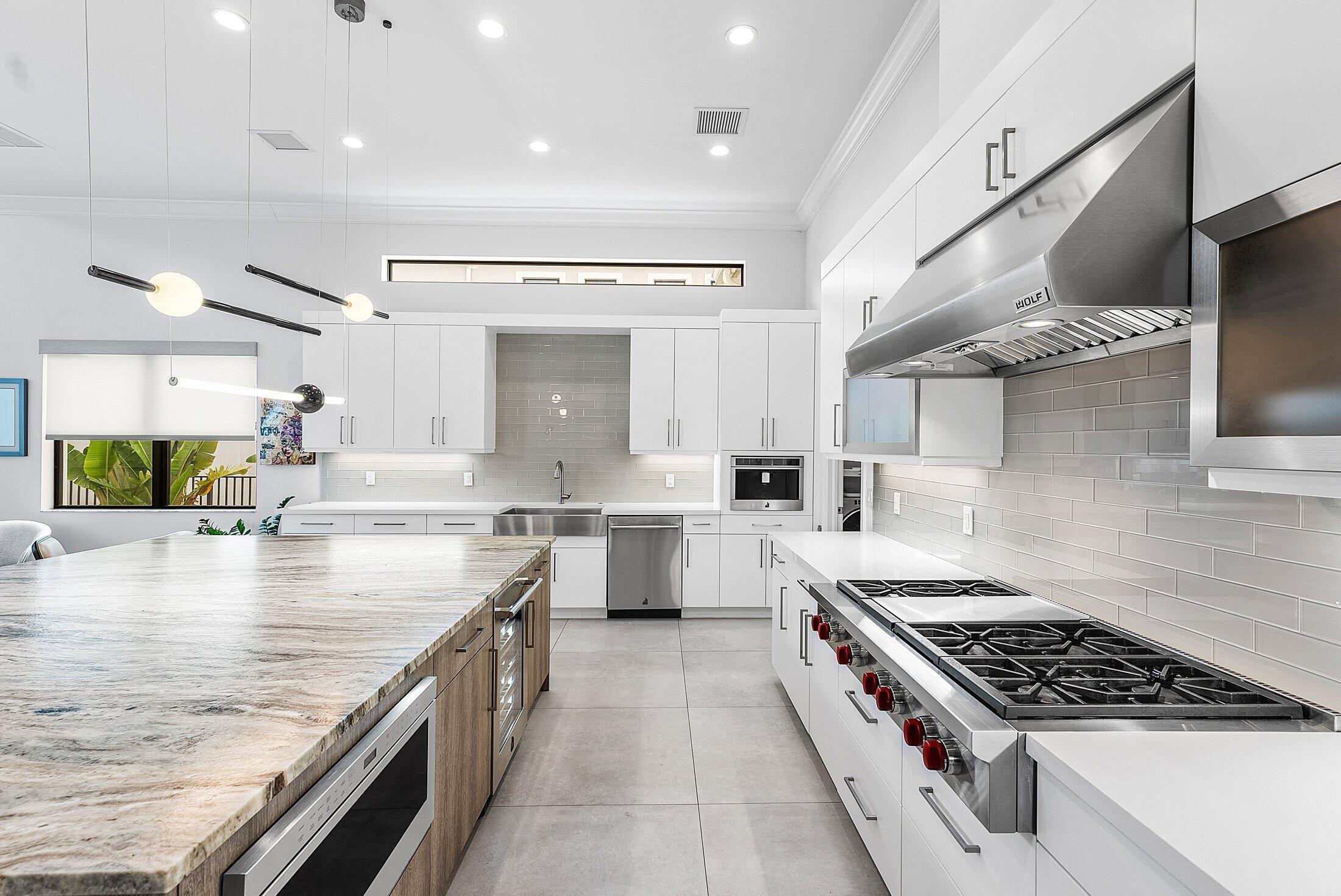 2707 Northwest 75th Street Boca Raton, FL 33496 - Photo 17 of 74 a kitchen with stainless steel appliances granite countertop a lot of counter space and wooden floors