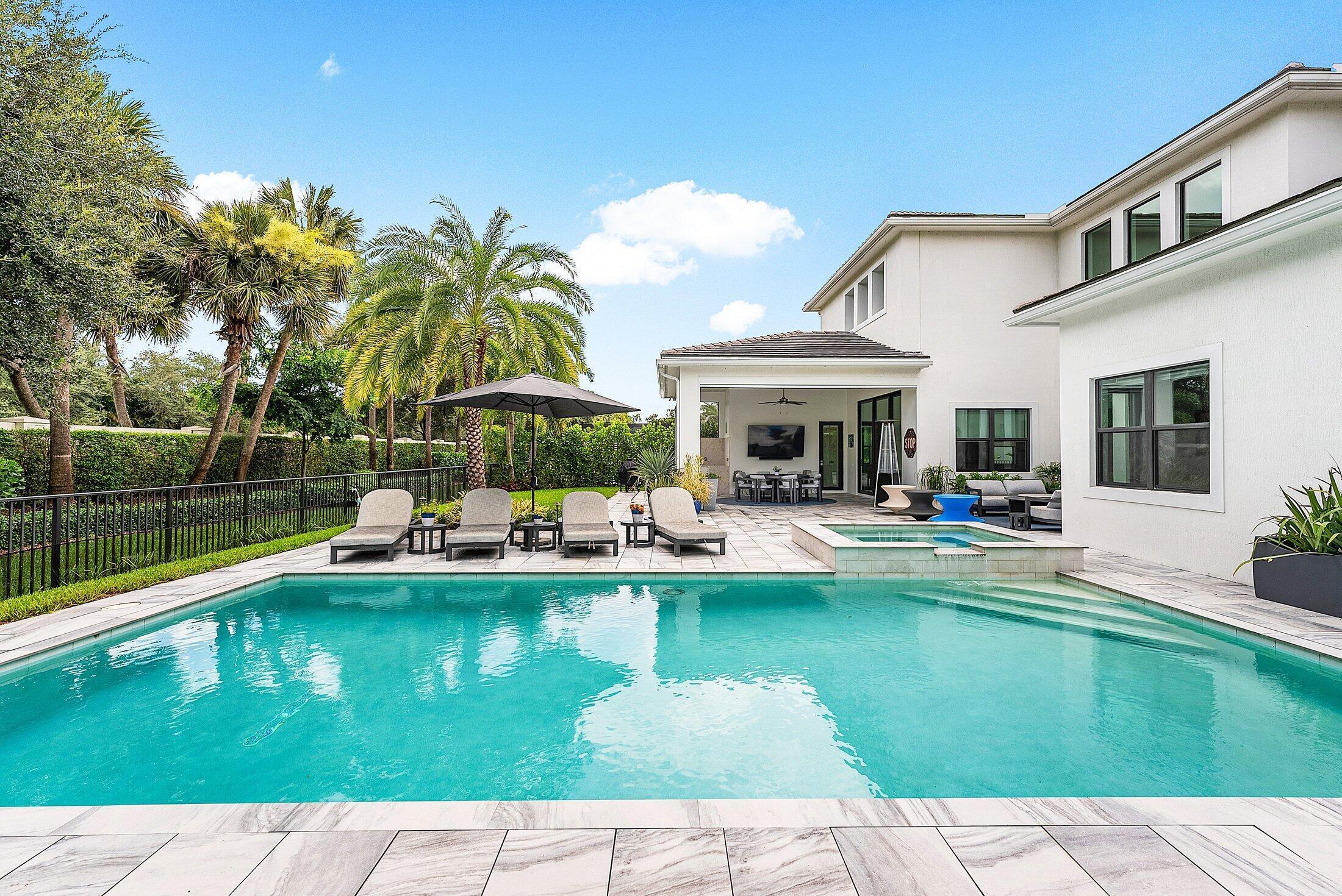 2707 Northwest 75th Street Boca Raton, FL 33496 - Photo 52 of 74 a view of a swimming pool with a table and chairs under an umbrella