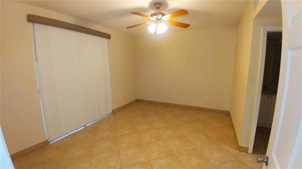 6640 West Sample Road, Unit 6640 Coral Springs, FL 33067 - Photo 11 of 25 an empty room with a ceiling fan and a window