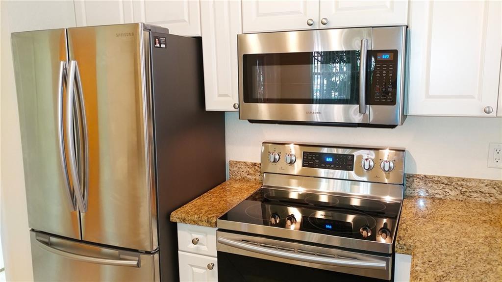 6640 West Sample Road, Unit 6640 Coral Springs, FL 33067 - Photo 9 of 25 a kitchen with stainless steel appliances granite countertop a refrigerator and a microwave