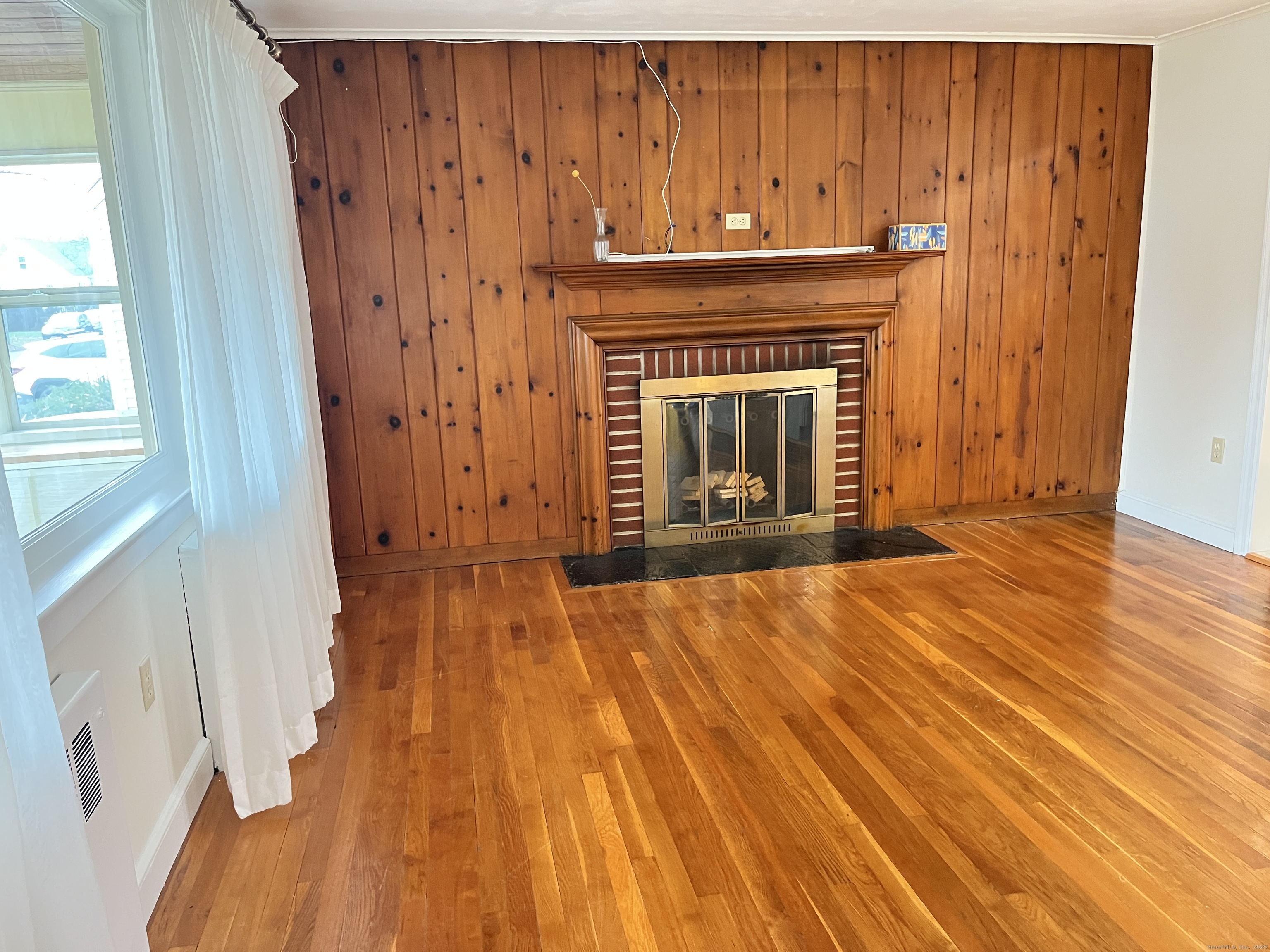 41 Baxter Drive Norwalk, CT 06854 - Photo 8 of 18 a view of an empty room with wooden floor and a fireplace