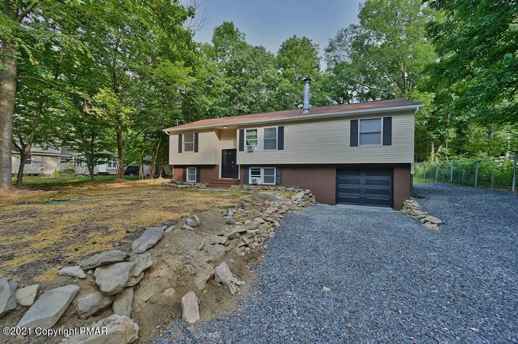 102 Forest Road Dingmans Ferry, PA 18328 - Photo 1 of 75 a front view of a house with a garden and trees