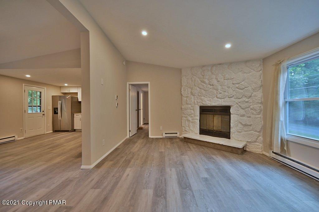 102 Forest Road Dingmans Ferry, PA 18328 - Photo 11 of 75 an empty room with wooden floor and fireplace